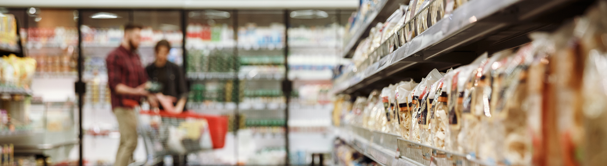 Concentrated young loving couple in supermarket choosing products