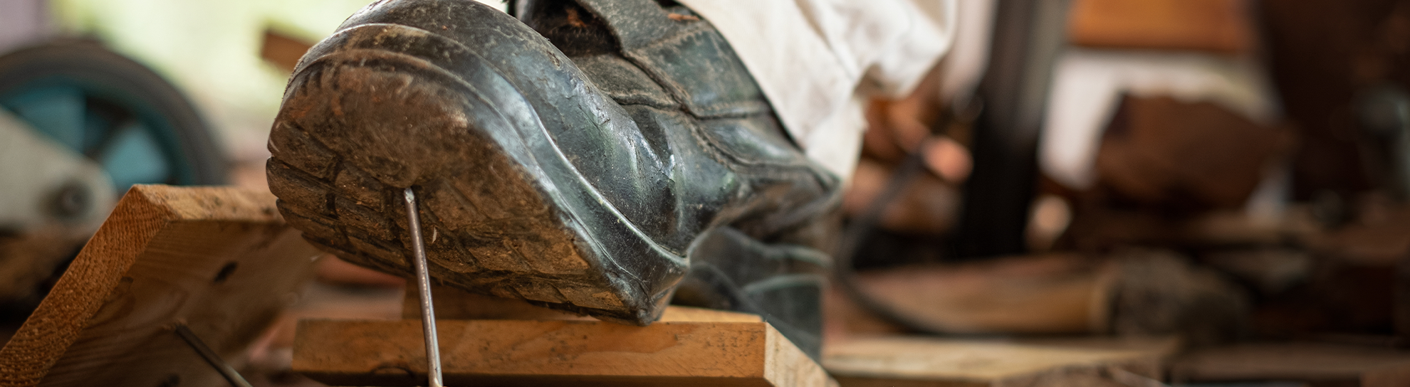 Worker in safety shoes stepping on nails on board wood In the construction area