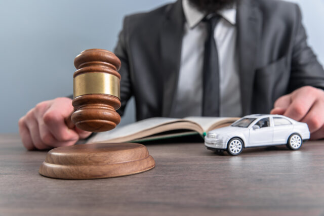 Judge with toy car and gavel on table