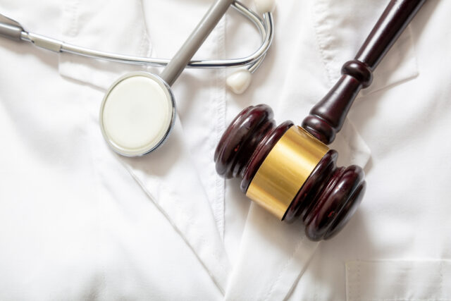 Medical malpractice, personal injury lawyer. Health and Law. Judge gavel and stethoscope on doctor coat, top view