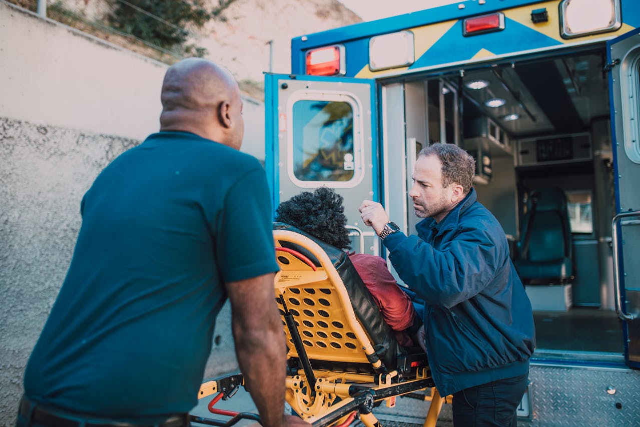 An african american woman being loaded on gurney into an ambulance by 2 male EMTs; Lakewood Ranch Personal Injury Lawyers concept image